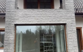 Realizacja boniówki granitowej 15x30 cm – elewacja domu góralskiego, front z panoramicznym oknem i balkonem, granit łupany