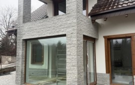 Realizacja boniówki granitowej 15x30 cm – elewacja domu góralskiego, kolumny i przyziemie oblicowane granitem, widok ogólny