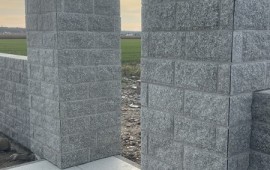 Realizacja ogrodzenia z boniówki granitowej 15x30 cm – dwa słupki bramowe przy nowej posesji, granit łupany