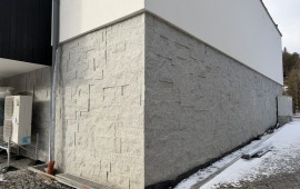 Realizacja elewacji z kamienia granitowego 3D – cokół i narożnik budynku wielorodzinnego, nieregularny układ płyt